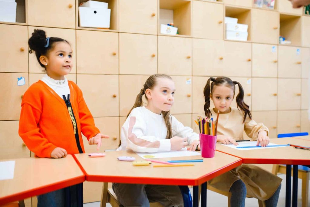 three primary school girls work together in the classroom