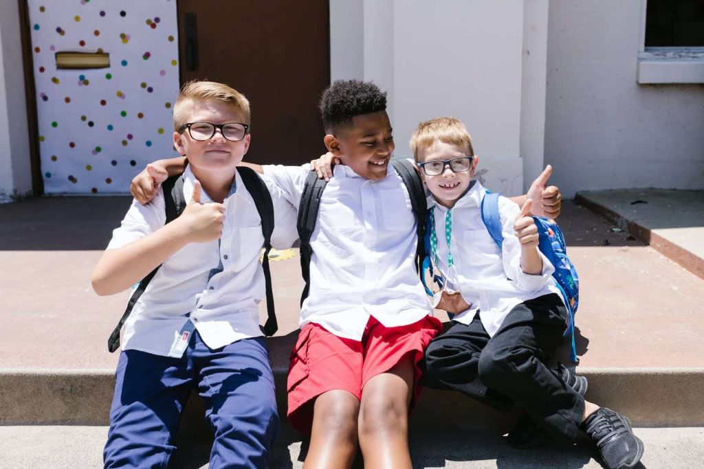happy school boys hugging on school steps