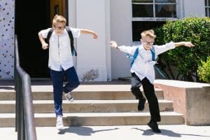 two school boys bounce down the school steps